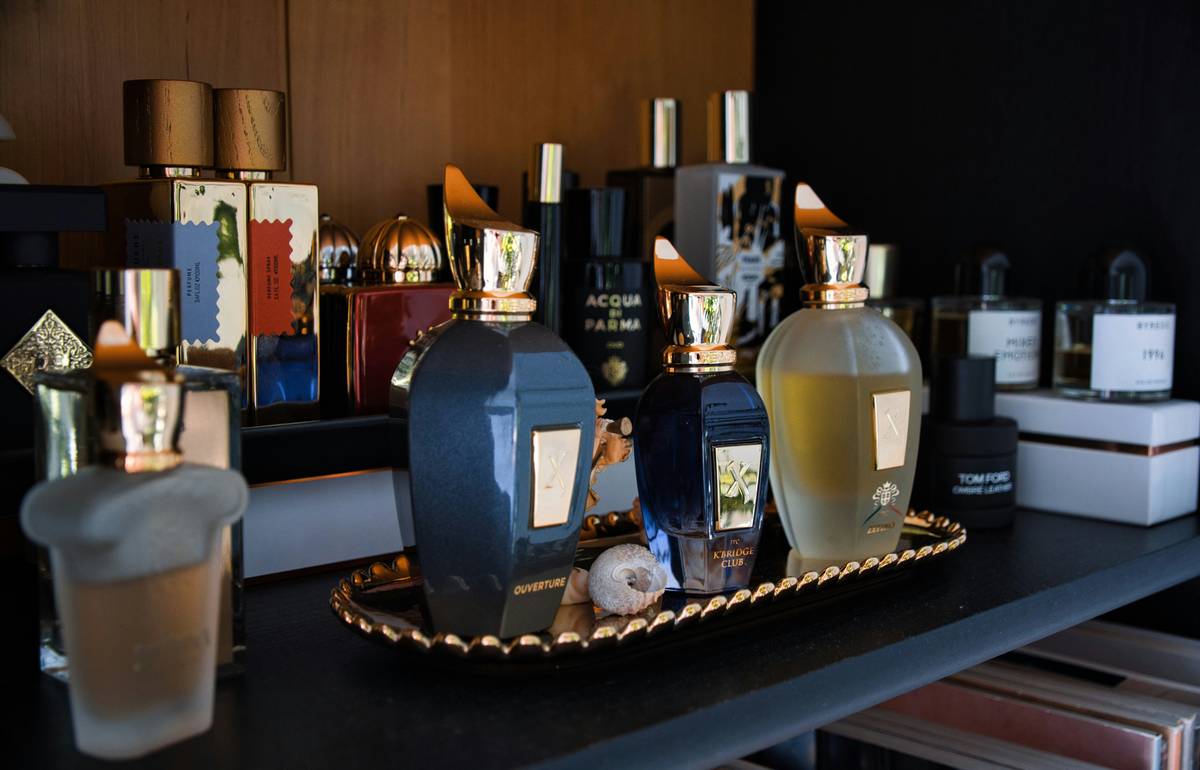 A clear acrylic beauty organization rack displaying neatly arranged makeup brushes, compacts, and skincare bottles